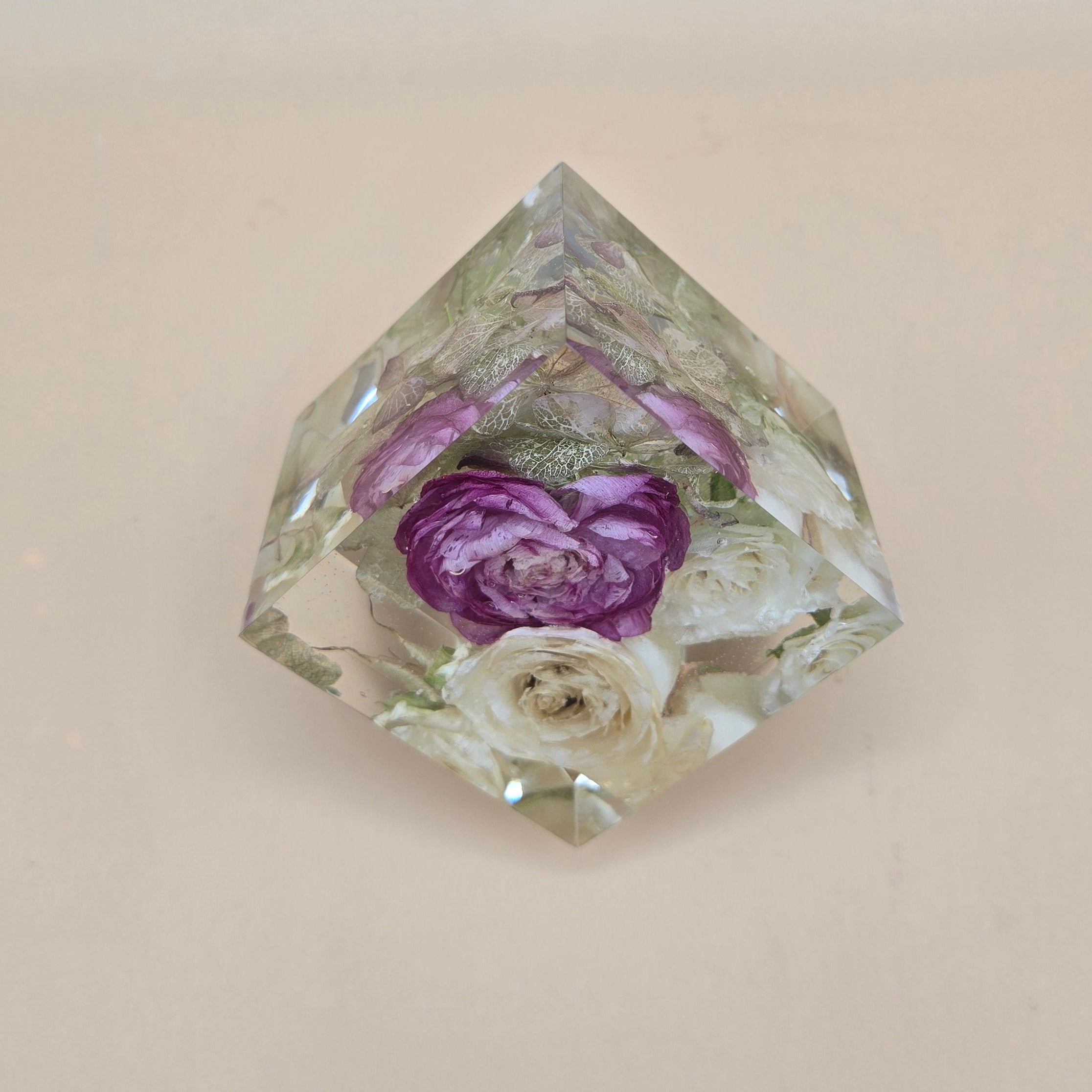 Resin cube preserved roses with embedded flowers on a beige background